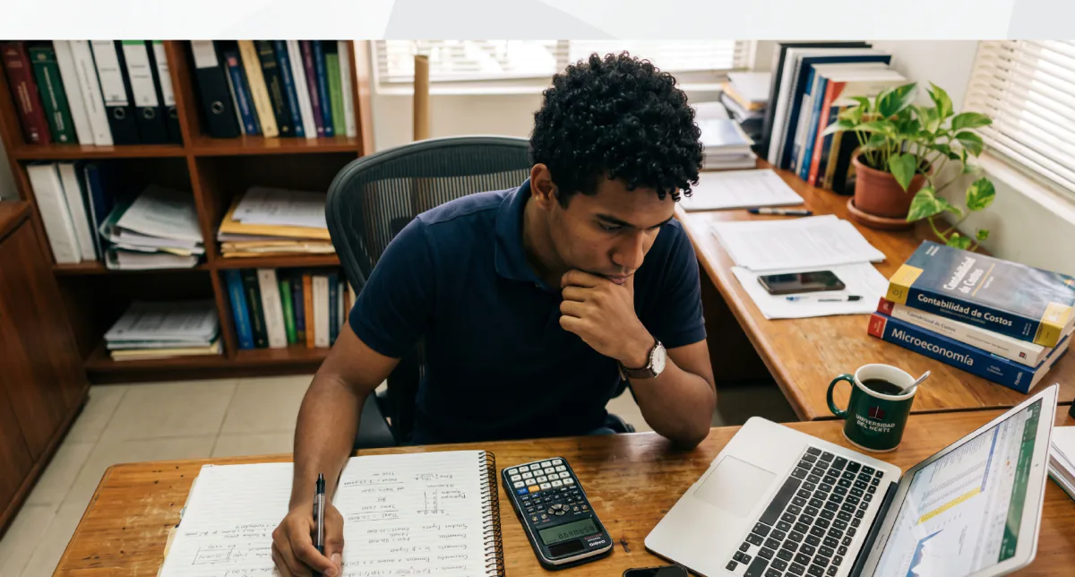 Estudiante de Administración de Empresas a Distancia trabajando con laptop en un coworking moderno